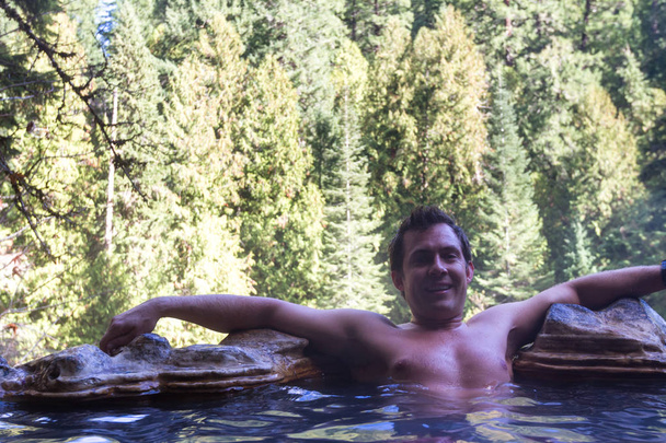 człowiek, relaksujący gorących basenów otoczony lasem w górach Oregon - Zdjęcie, obraz
