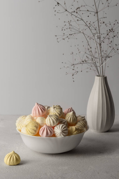 sweet marshmallow in the cup, delicious dessert, on a gray background a vase with a branch - Foto, immagini