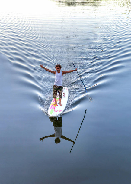 サーフボードの上で男が川に浮かんでいます。マイエンヌ、ラヴァル市は、フランス、ロワールを支払っています。2018 年 8 月 5 日 - 写真・画像