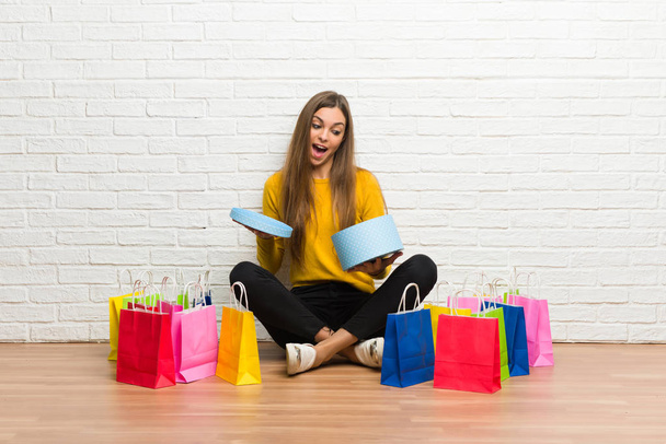 junges Mädchen mit vielen Einkaufstüten hält Geschenkbox in den Händen - Foto, Bild
