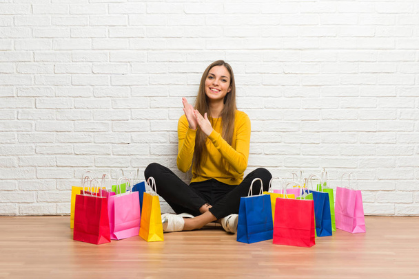 Young girl with lot of shopping bags applauding after presentation in a conference - Photo, Image