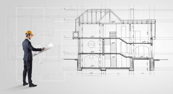 Architect looking to a house plan - Фото, изображение