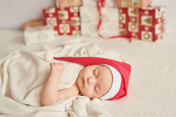 Santa baby with a New Year's decoration on a light background - Photo, image