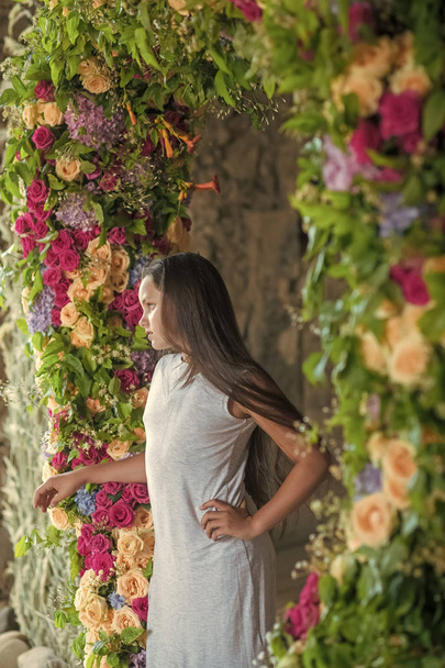 Teenage girl with long hair stand in flower arch, beauty - Фото, зображення