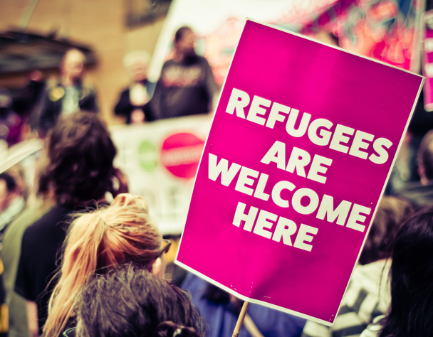 Drukke straat protest maart met een bord Zeggen vluchtelingen zijn welkom Heren - Foto, afbeelding