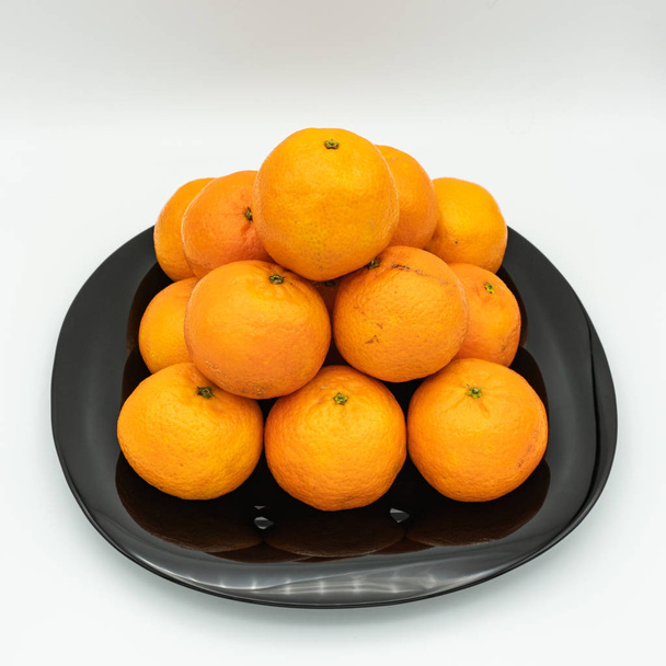 Mandarine ist die Frucht der verschiedenen Zitrusarten, die gemeinhin als Mandarinen bezeichnet werden, darunter Citrus reticulata, Citrus unshiu, Citrus reshni sowie deren Hybriden, einschließlich Citrus tangerina, deren Taxonomie diskutiert wird. - Foto, Bild