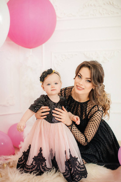Happy mother with cute daughter in room on Birthday party.   - Foto, Imagen