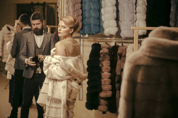 Woman in fur coat with man, shopping, seller and customer. - Foto, imagen