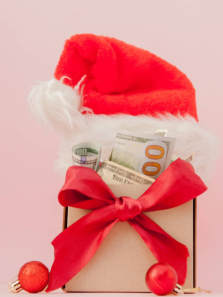 New year gift box with dollars on pink background close up. - Foto, Imagen