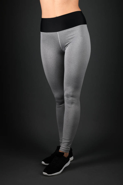 Junge Fitness-Frau in Sportkleidung auf schwarzem Hintergrund - Foto, Bild