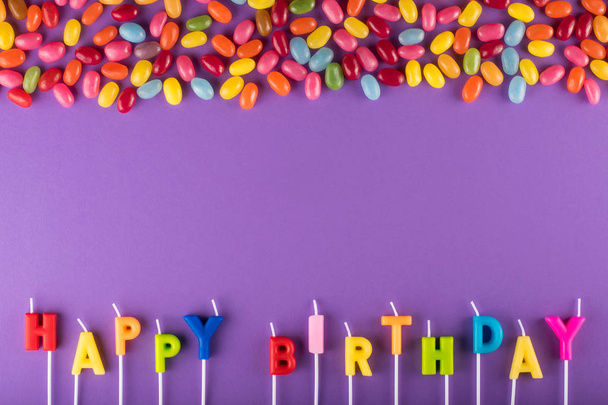 Colorful Happy Birthday candles for cake and jelly beans - Foto, imagen