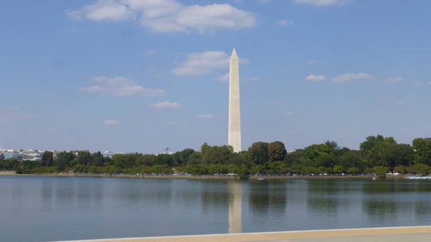 Pomnik Waszyngtonu w pochmurnym błękitnym niebie nad rzeką - Zdjęcie, obraz