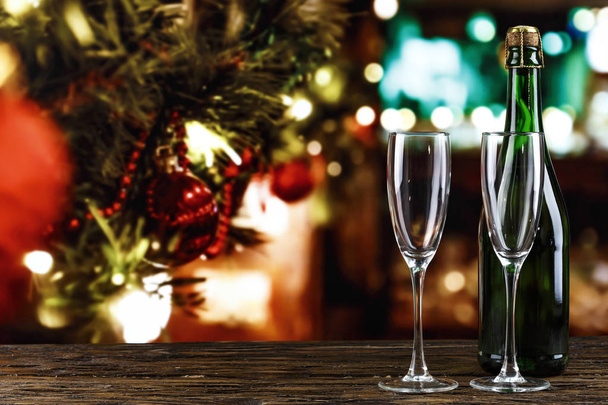 champanhe em copos e em uma garrafa no fundo de bokeh. Antecedentes de Natal. espaço para tex
 - Foto, Imagem