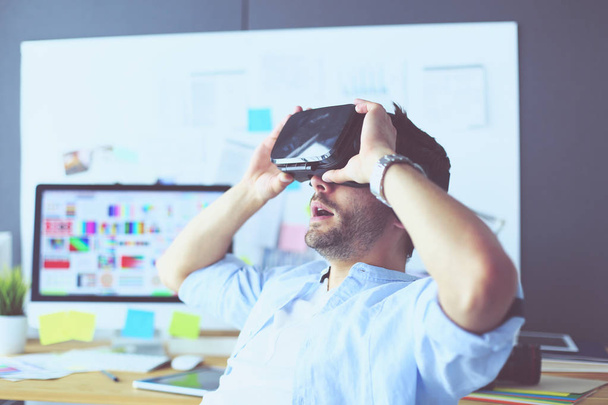 Young male software programmer testing a new app with 3d virtual reality glasses in office. - Foto, Imagem
