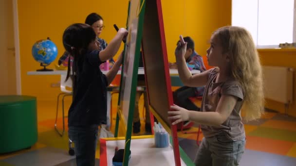 Mädchen malen im Unterricht auf Staffelei - Filmmaterial, Video