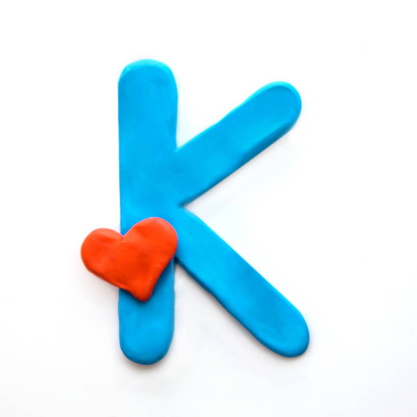 Blue plasticine letter K English alphabet with red heart meaning love on Valentine's day, isolate on white background - Photo, Image