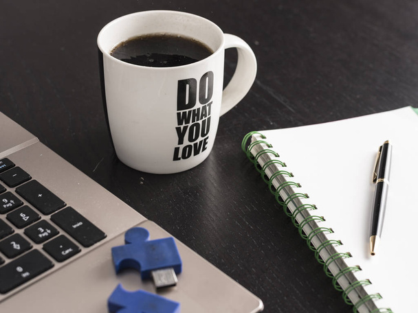 bodegón con cuaderno, bolígrafo y una taza de café blanco sobre un escritorio de oficina negro. símbolo de trabajo
 - Foto, Imagen