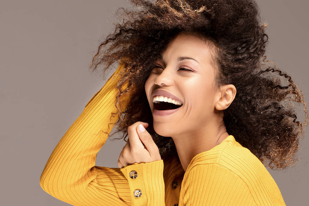 Happy african american woman smiling. Beautiful female half-length portrait. Young emotional afro woman. The human emotions, facial expression concept. - Photo, image