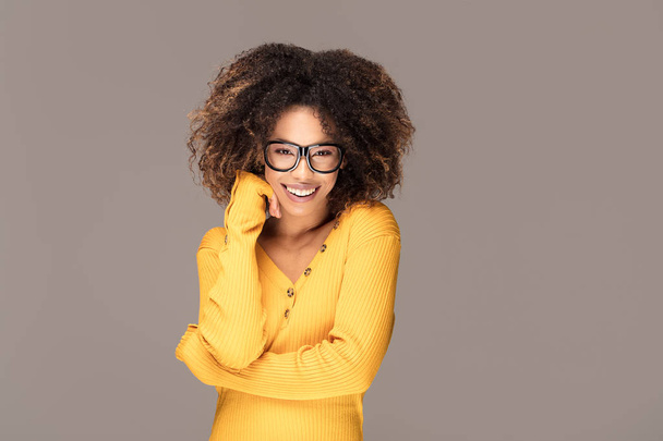 Young beautiful african american girl with an afro hairstyle. Laughing girl wearing eyeglasses. Portrait. Girl looking at camera. - Zdjęcie, obraz