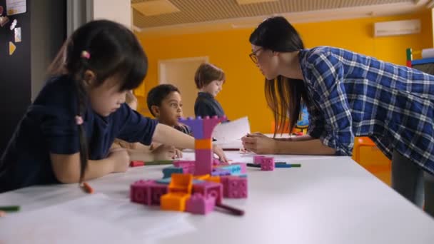 Lehrerin arbeitet im Kindergarten mit kreativen Kindern - Filmmaterial, Video