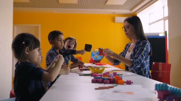 Multikulturelle Kinder basteln Schiff mit buntem Papier - Filmmaterial, Video