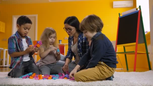 Kinder spielen im Kindergarten mit Spielzeugklötzen - Filmmaterial, Video