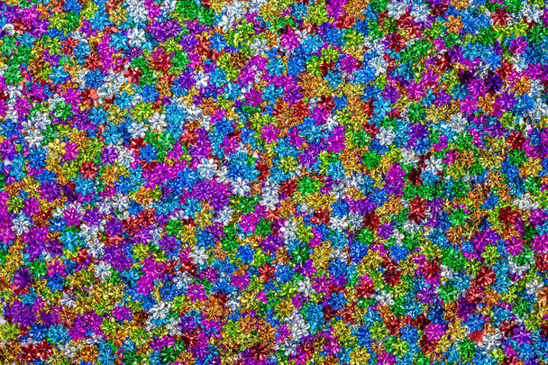 πολύχρωμα γκλίτερ σε σχήμα λουλουδιού έχουν πολλά φρέσκα χρώματα και λάμψη - Φωτογραφία, εικόνα