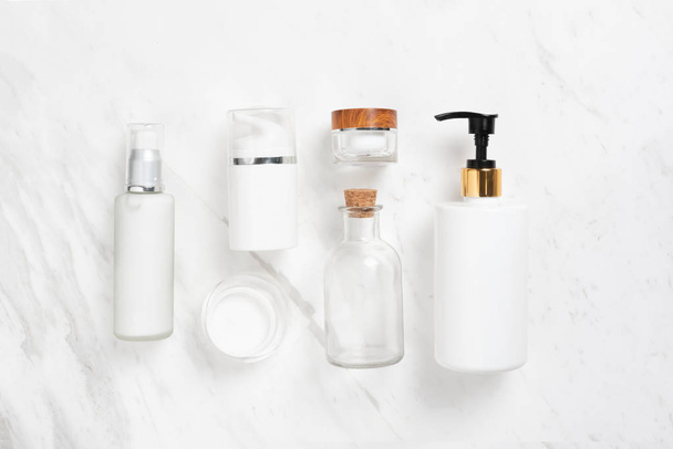 Spa products. Top view of Cosmetic bottles on white marble background. Copy space. - Foto, afbeelding