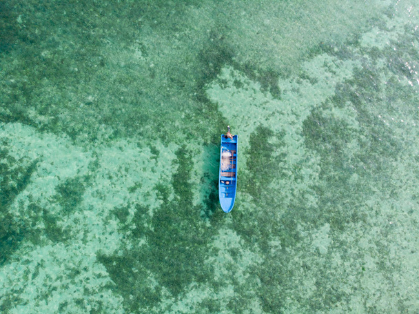 Повітряні зверху вниз подання човен каное плаває на бірюзове коралових рифів тропічних Карибського моря. Індонезія Молуккські острови архіпелагу, Кей-острова, Море Банда. Топ подорожі, кращий, Дайвінг, підводне плавання. - Фото, зображення
