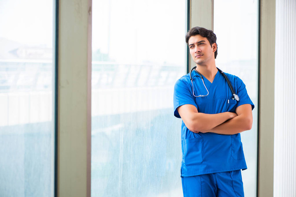 Young handsome doctor working in the hospital  - 写真・画像