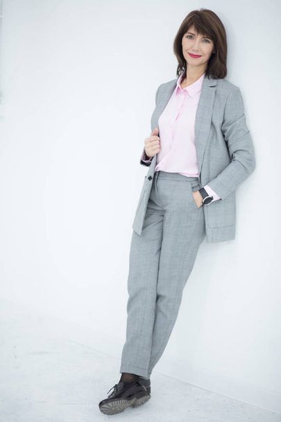 Close up portrait of a serious business woman in gray suit standing in the city - Foto, Imagem