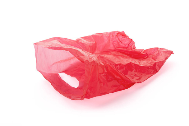 Sacchetto di immondizia vuoto di plastica rossa galleggiante isolato su sfondo bianco, percorso di ritaglio intorno al sacchetto, non intorno all'ombra gettata, incluso
. - Foto, immagini