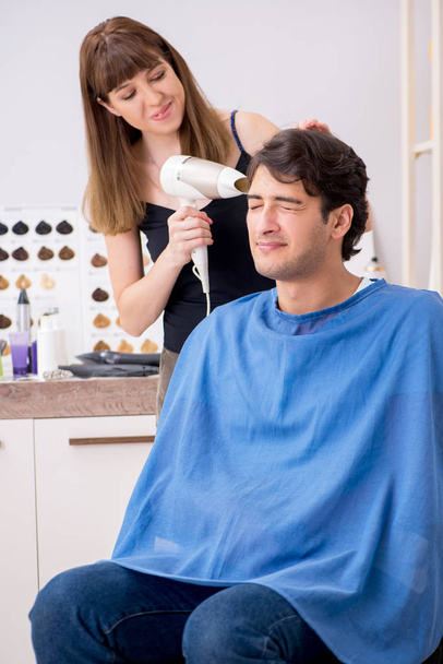 młody atrakcyjny mężczyzna odwiedzając kobieta fryzjer  - Zdjęcie, obraz