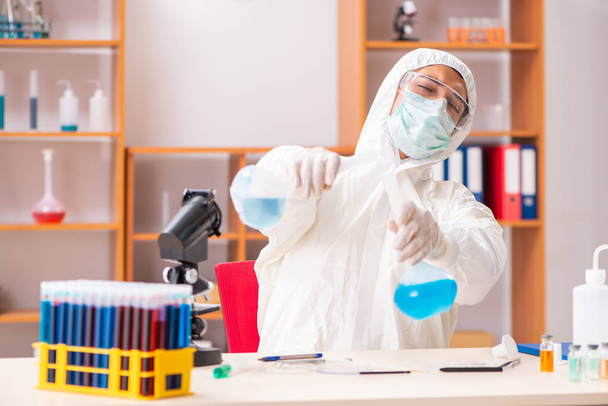 Młody biochemik w kombinezonie ochronnym pracujący w laboratorium - Zdjęcie, obraz