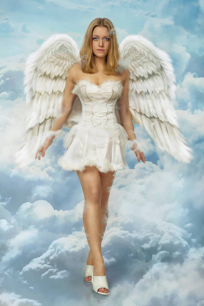 Όμορφη νεαρή ξανθιά γυναίκα Άγγελος περπάτημα στο ουρανό σύννεφα με λευκά φτερά - Φωτογραφία, εικόνα