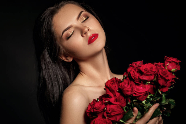 beautiful young woman with a large bouquet of red roses - Foto, Bild