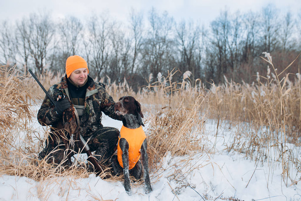 hunter and dog are in the winter forest - Foto, Imagen