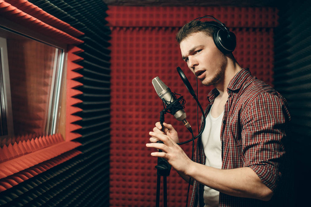 handsome awesome singer standing with microphone in the recording room - Фото, зображення