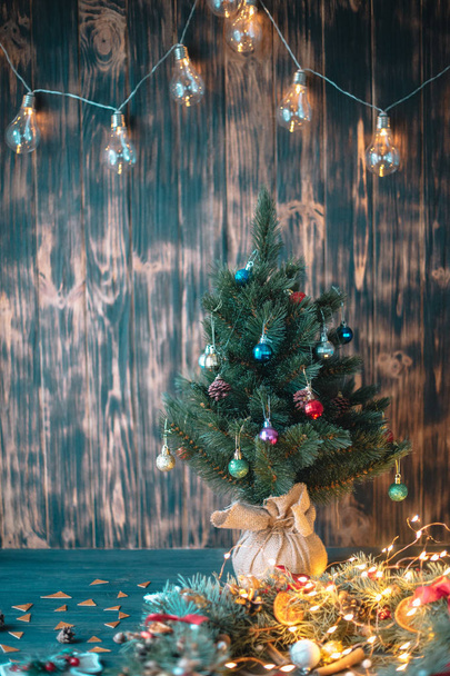 Christmas tree branch and lights on wooden background. View with copy space - Fotoğraf, Görsel