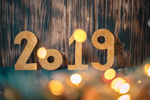 The inscription 2019 on the background of New Year's decorations on a wooden background - 写真・画像