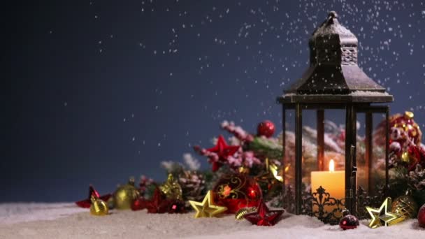 Burning candles , lantern and christmas decoration on snowfall background - Footage, Video