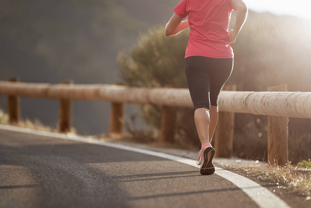 Fitness femme coureuse athlète courir sur la route, travailler cardio sur la nature paysage - Photo, image