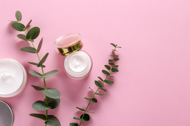 Moisturizing care skincare face cream for healing complicated troubled skin type in an open jar with visible texture. Copy space, close up, background, flat lay, top view. Eucalyptus leaf decoration. - Foto, immagini