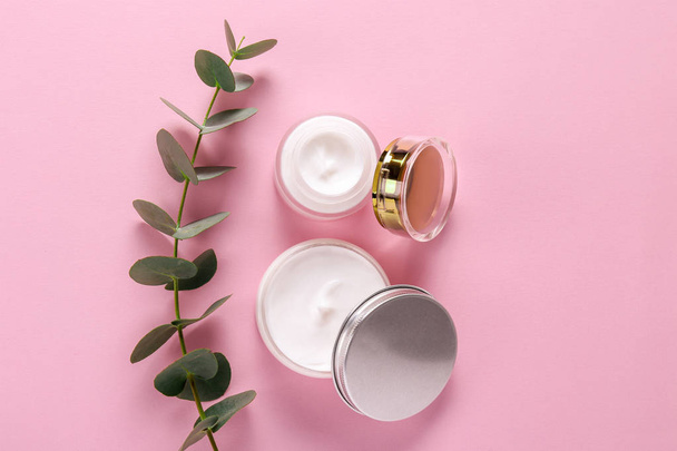 Moisturizing care skincare face cream for healing complicated troubled skin type in an open jar with visible texture. Copy space, close up, background, flat lay, top view. Eucalyptus leaf decoration. - Foto, imagen