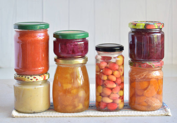 Variedade de comida preservada em jarros de vidro - escabeches, engarrafamento, escabeche, molhos, ketchup. Preservação de legumes e frutas. Comida fermentada. Enlatamento de outono. Conservação da colheita
. - Foto, Imagem