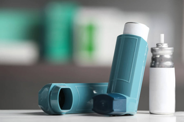 Asthma inhalers on table against blurred background. Space for text - Foto, Imagem
