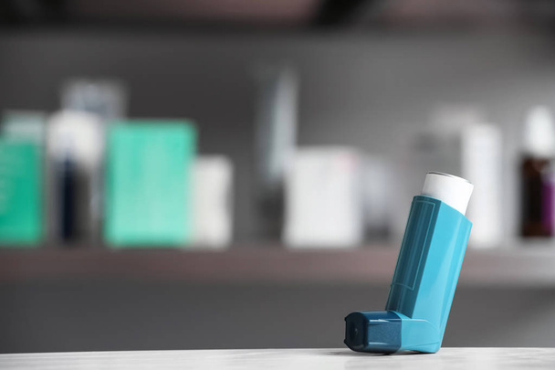 Asthma inhaler on table against blurred background. Space for text - Fotoğraf, Görsel