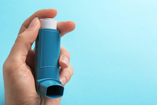 Woman holding asthma inhaler on color background. Space for text - Fotó, kép