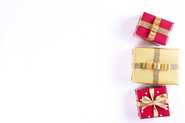 Multi purpose festive composition with present wrapped in colorful paper and tied with satin silk bow. Gift box for differet occasions. Close up, top view, copy space, background, flat lay. - 写真・画像