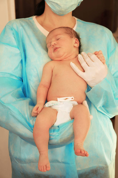 Doctor holding cute newborn child in hospital - Фото, зображення